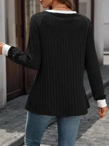 Vista posteriore di un maglione nero a coste con colletto e polsini bianchi a contrasto