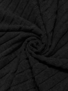 Primo piano macro che mostra la morbida trama a coste e il drappeggio del tessuto a maglia nera.
