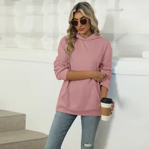 Outdoor view of a women's pink casual oversized hooded sweatshirt with pocket detail