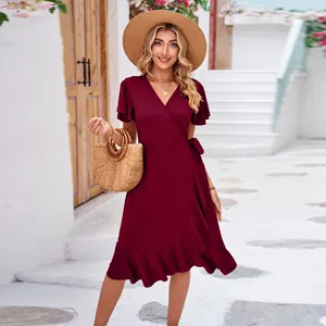 Detail view of an elegant burgundy V-neck wrap dress with flutter sleeves and ruffled hem.