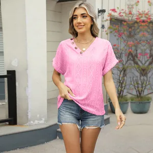 Detailed close-up of pink jacquard V-neck knit top featuring stylish decorative buttons