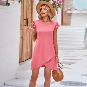 Casual pink ruffle sleeve dress with criss-cross hem shown in a Mediterranean street setting