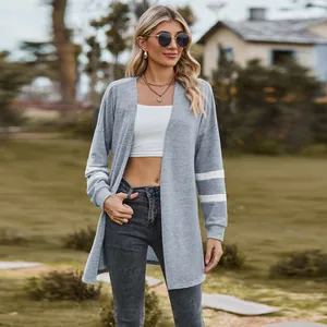Grey knit cardigan featuring white stripe detail on sleeves, worn over white crop top