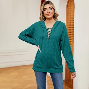 Detalle de sudadera con capucha para mujer en color verde azulado con cordones y tejido texturizado