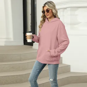 Lifestyle detail of a woman wearing a casual pink hooded sweatshirt with a front pocket