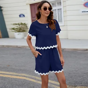 Detail shot of navy blue 2-piece set featuring stylish white scalloped trim on hems