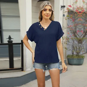 Close-up of navy blue V-neck knit top with jacquard diamond pattern and side buttons