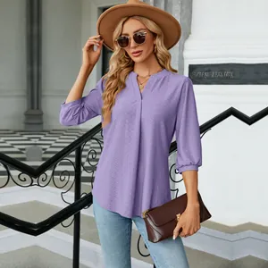Detalle de blusa jacquard morada con cuello en V, mangas 3/4 y un corte holgado