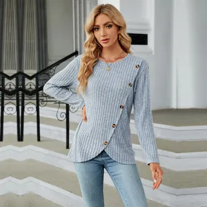 Detailed view of long-sleeved ribbed top with decorative buttons and tulip hemline.