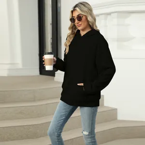 Close-up of a women's black oversized hooded sweatshirt with a front kangaroo pocket.