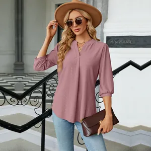 Primer plano de elegante blusa de jacquard malva con cuello en V en modelo al aire libre