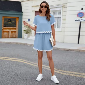 Outdoor view of women's light blue two-piece set with white scalloped trim