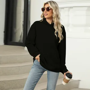 Casual oversized black hoodie with kangaroo pocket worn by model in outdoor setting