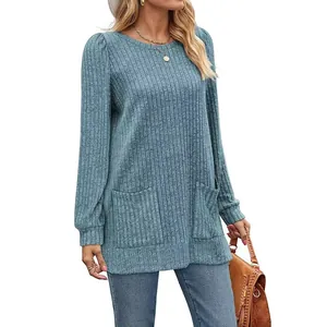 Detail view of a women's light blue ribbed knit top with puff sleeves and pockets