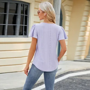 Back view of women's lavender eyelet lace short sleeve top in an outdoor setting