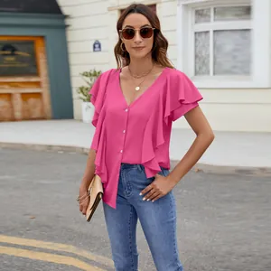 Close-up of pink ruffle flutter sleeve top with button-down front on model outdoors.