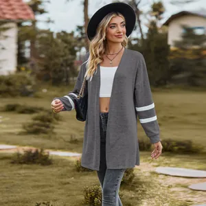 Close-up of stylish grey long-sleeved knit cardigan with white athletic sleeve stripes