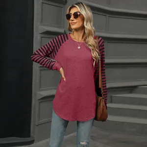 Detail of women's long sleeve color block t-shirt with striped sleeves and curved hem