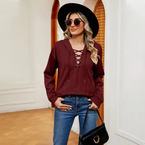 Detalle de una sudadera con capucha granate con cordones para mujer en ambiente elegante