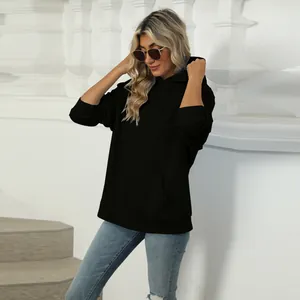 Close-up view of a casual black oversized hoodie featuring a front kangaroo pocket design.