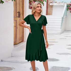 Full body shot of a green V-neck wrap dress with ruffle hem in a summer street setting.
