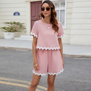 Pink two-piece summer set with scalloped white trim on a model in street scene