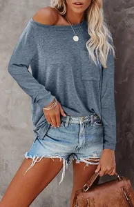 Detail van los blauw T-shirt met lange mouwen, borstzak en distressed korte broek