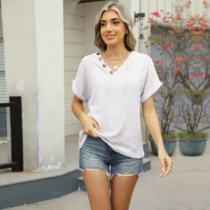 Detailed look at white V-neck shirt featuring jacquard knit and button accents on model.