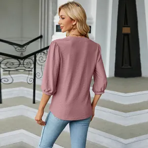 Vista trasera detallada de mujer con top de jacquard rosa palo y cuello en pico elegante