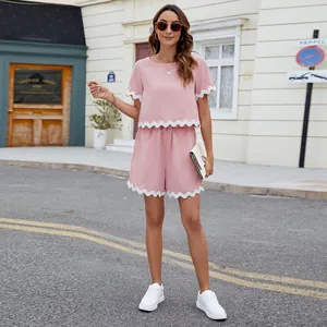 Stylish pink women's two-piece set with white scalloped trim on T-shirt and shorts