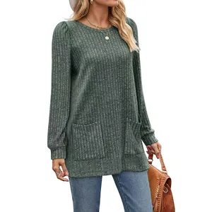 Detail of loose green ribbed knit top with puff sleeves and front pockets