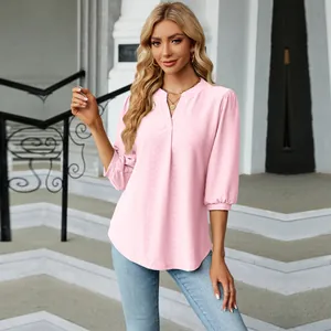 Detalle de blusa de jacquard rosa con escote en V y elegantes mangas tres cuartos