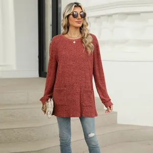 Outdoor view of a woman wearing a casual reddish-brown knit top with front pockets