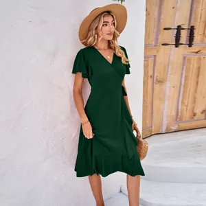 Full-length detail of a dark green wrap dress with a V-neck and elegant ruffle hem