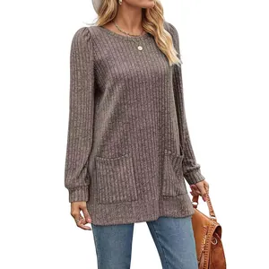 Close-up of brown ribbed tunic top featuring functional front pockets and puff sleeves.