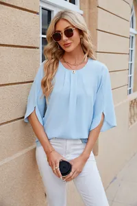 Detail showing the light blue chiffon blouse with pleated neck and split sleeves on model.