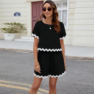 Detail view of black short sleeve two-piece set with white scalloped trim for women