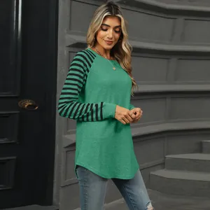 Close-up detail of a women's green long sleeve t-shirt featuring black striped raglan sleeves.