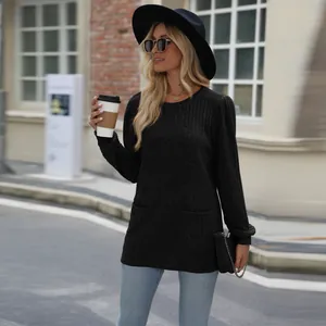 Detail view of a woman wearing a black ribbed puff sleeve knit top with pockets and a fedora.