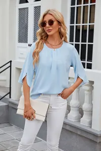 Elegant light blue chiffon blouse with round neck and split sleeves shown on model outdoors.