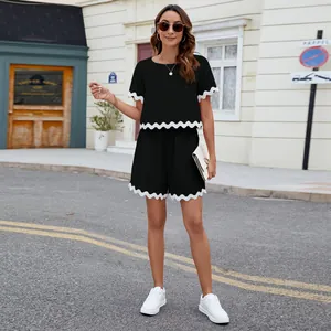 Full view of black two-piece set featuring white scalloped trim t-shirt and shorts