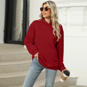 Detail view of a stylish red oversized hooded sweatshirt with a kangaroo pocket.