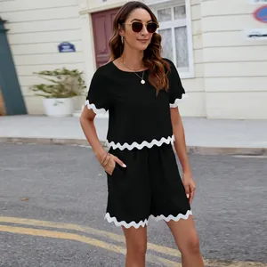 Two-piece summer set in black with distinctive white scalloped trim and crew neck
