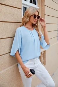 Woman wearing a light blue round neck chiffon blouse with half sleeves outdoors