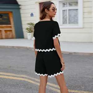 Back view of black two-piece set with white wavy trim t-shirt and shorts
