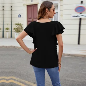 Rear view detail of black ruffle sleeve blouse on model in street setting