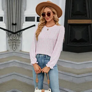 Detailed view of the delicate pink floral print and ruffled cuffs on this women's autumn top