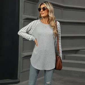 Close-up of grey long-sleeve T-shirt with striped patchwork sleeves and curved hem