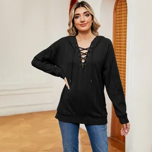 Vista completa de sudadera negra con capucha y escote con cordones en modelo mujer