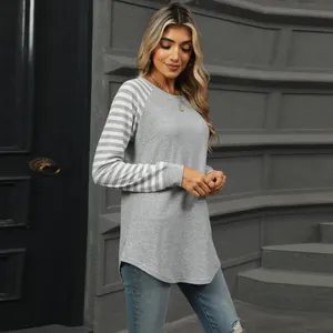 Detail view of a grey striped raglan sleeve T-shirt with curved swallowtail hem.